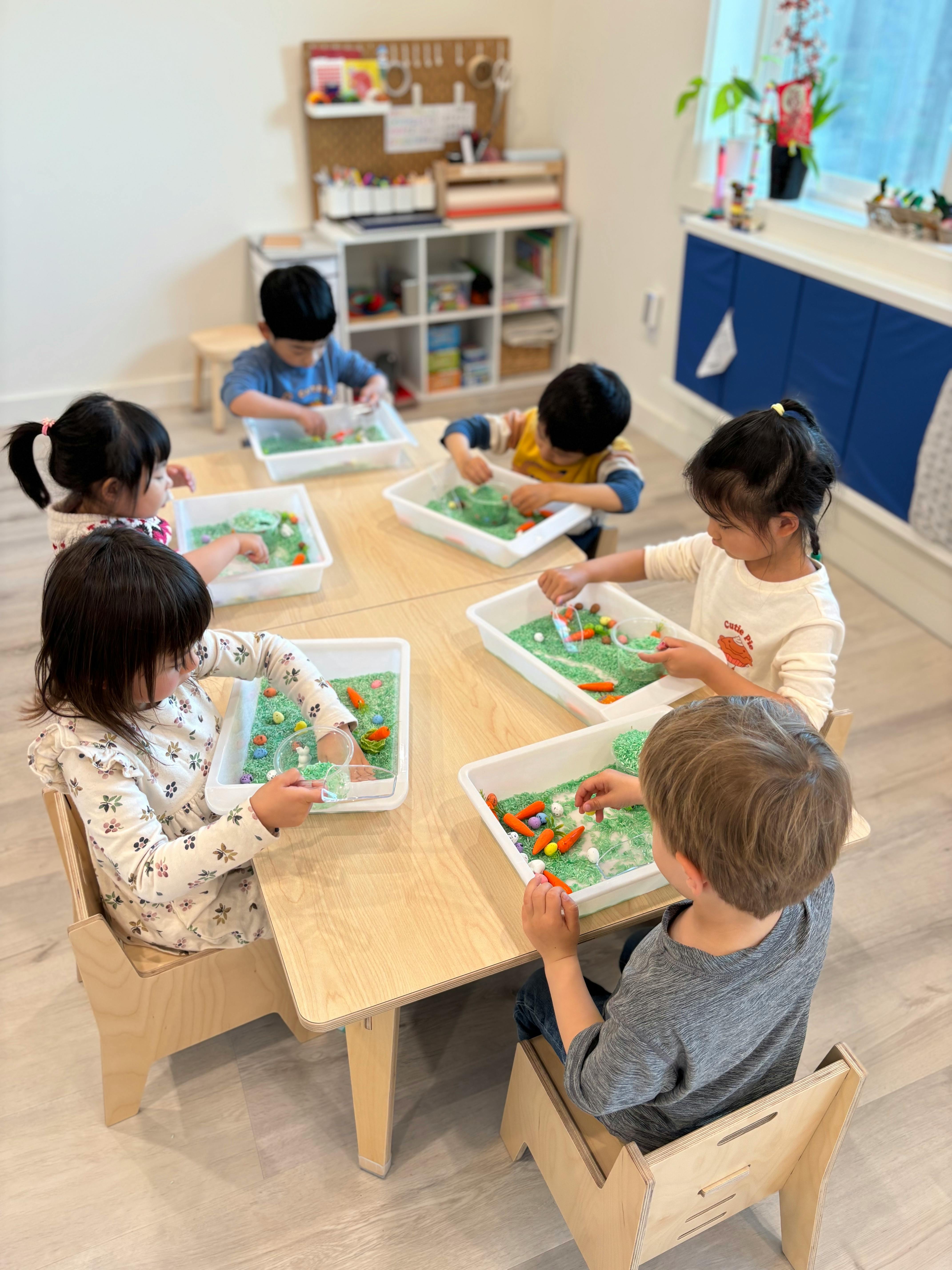 Children at a table playing with sensory bins