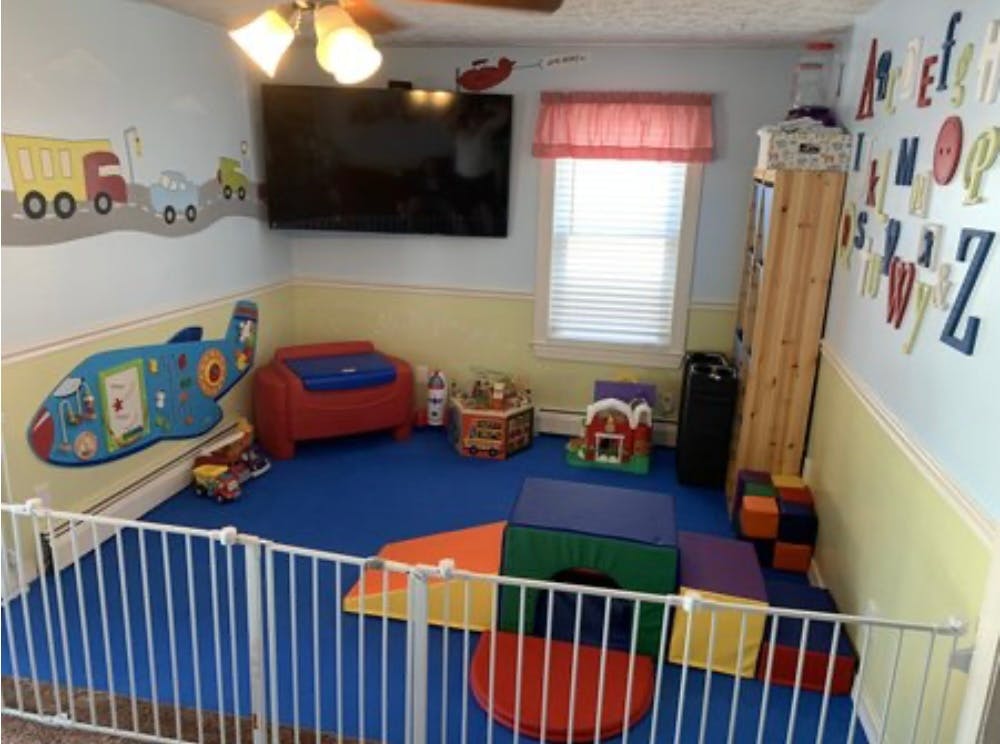 Playroom with a blue mat, soft play equipment, and a white safety gate