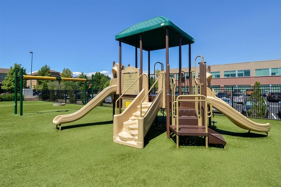 Playground with slides and climbing structures on artificial turf