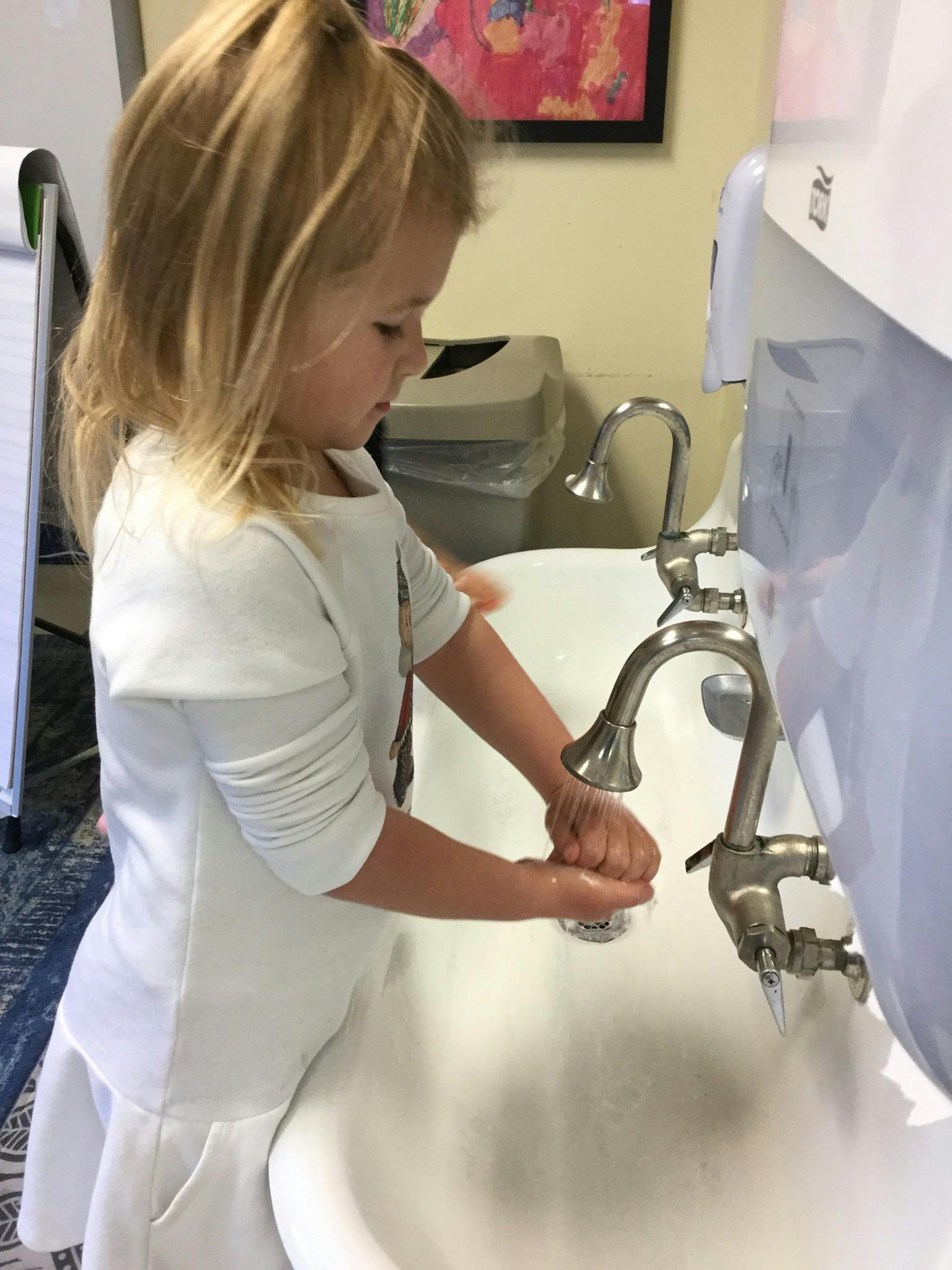 Child washing hands at a sink