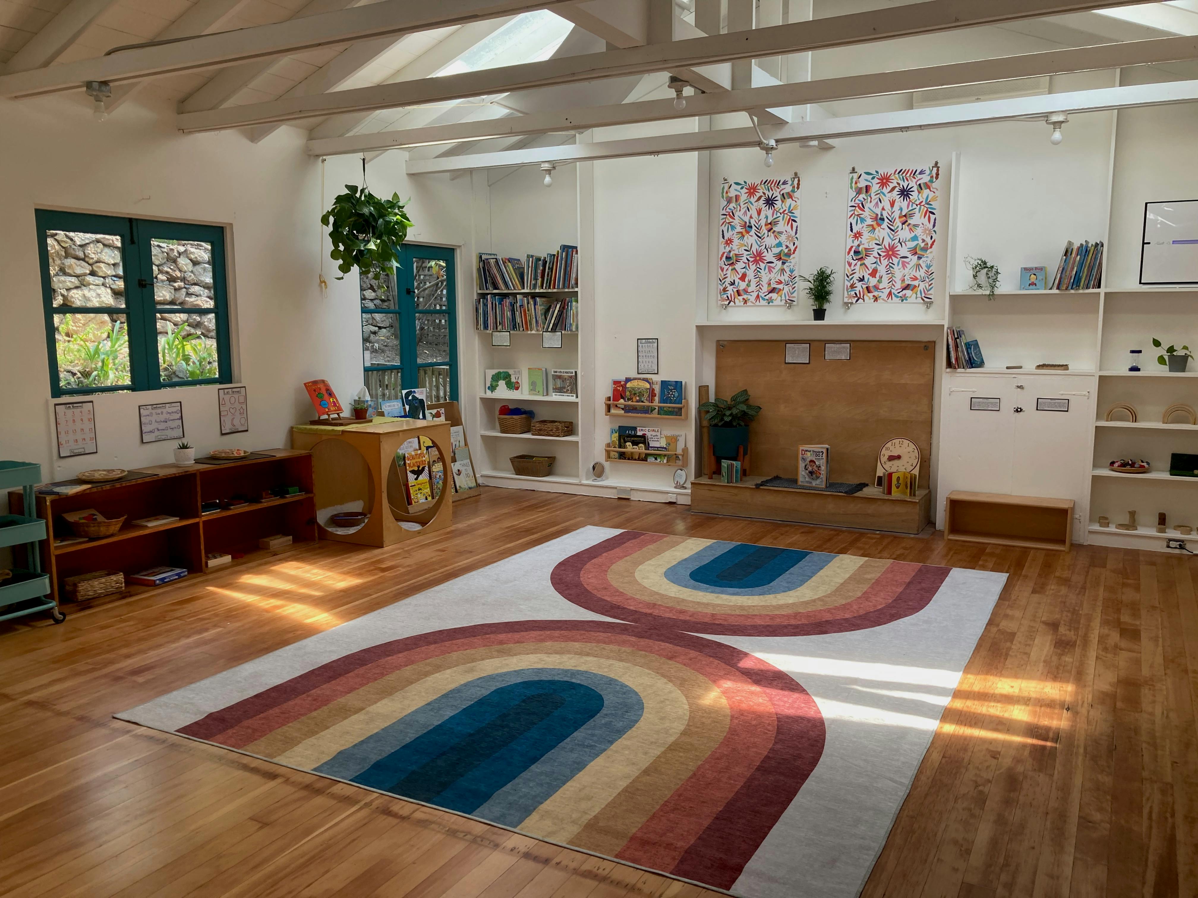 Classroom with rainbow rugs on a wooden floor