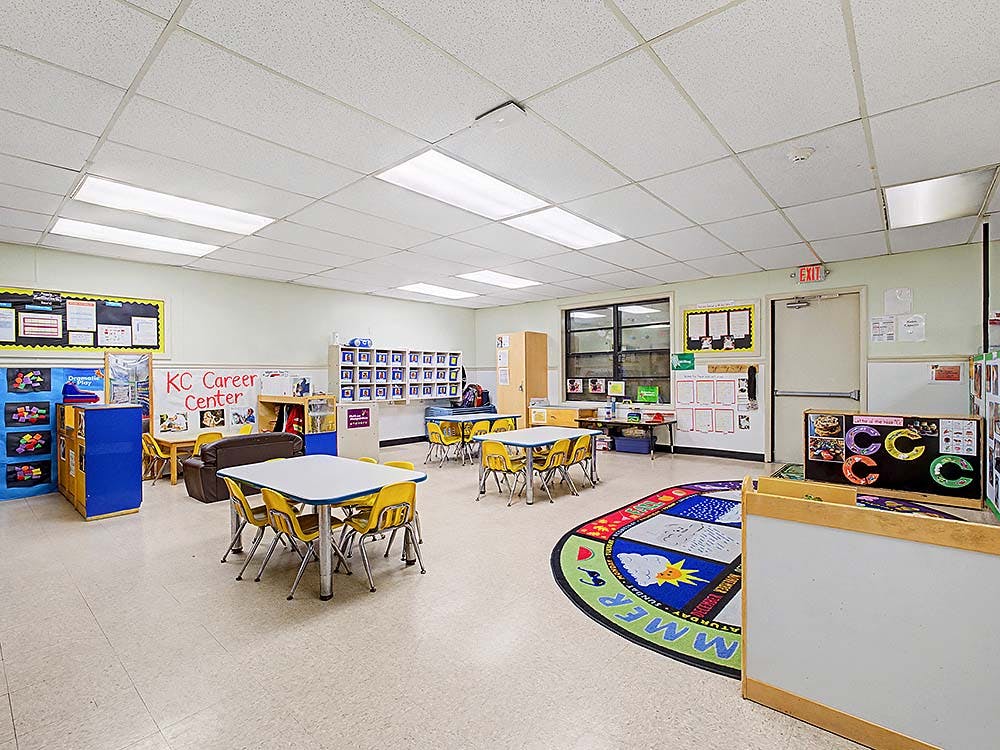 Empty colorful children's classroom with small tables and chairs