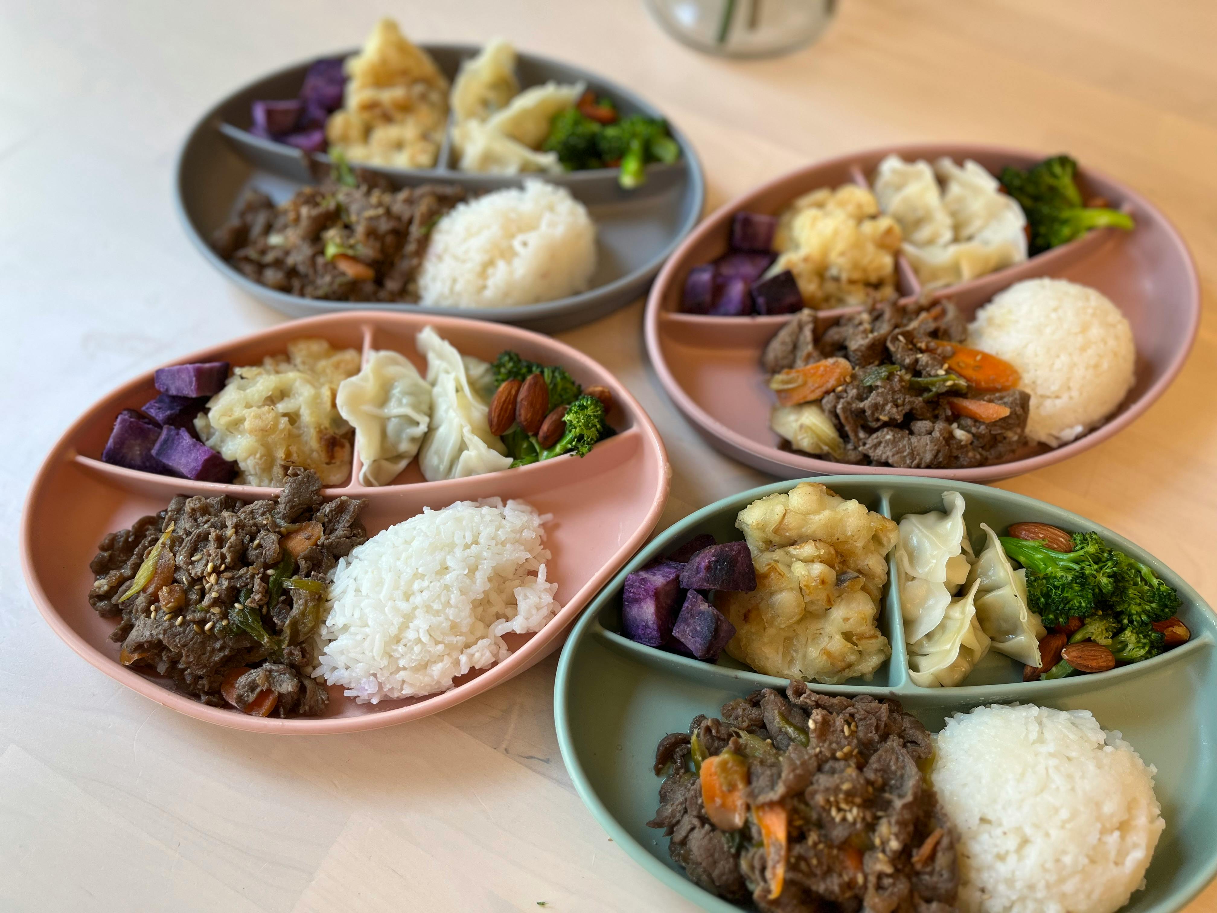 Four divided plates with rice, meat, and vegetables