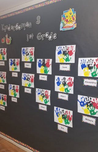 Handprint art on a classroom wall with "Kindergarten & 1st Grade" text