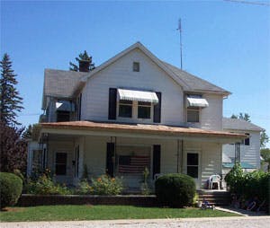 White house with a porch and awnings