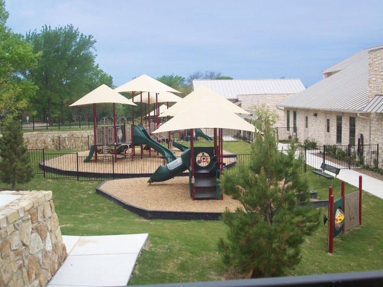 Playground with slides and climbing structures under shade canopies