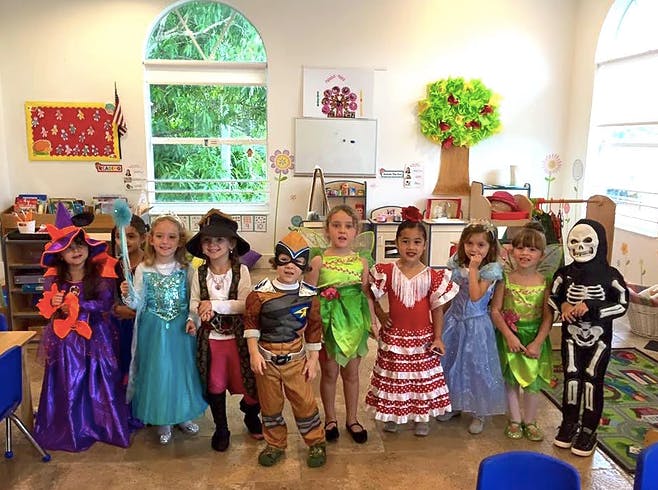 Group of children in various costumes standing in a room