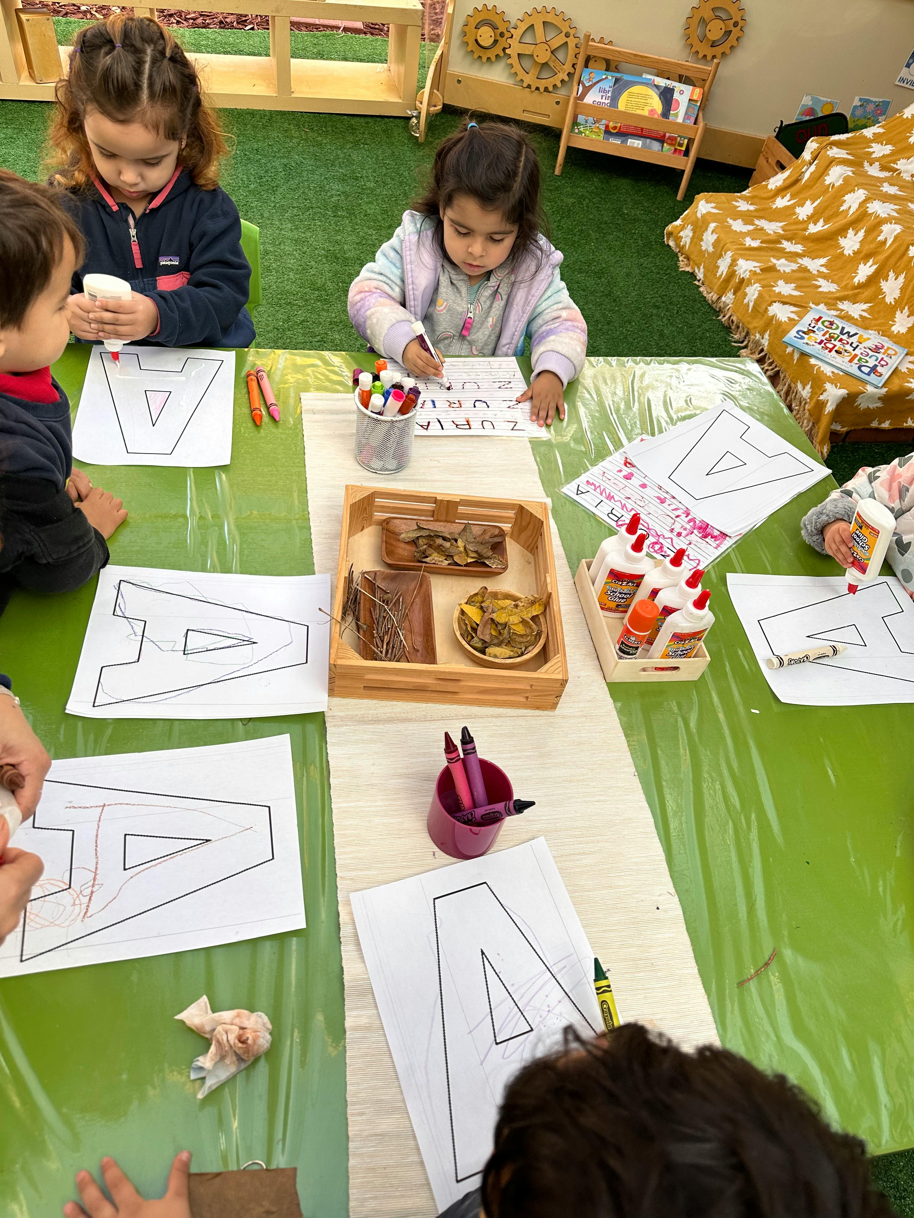 Children at a table working on crafts with paper and glue