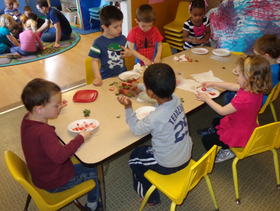 Children sitting at a table with plates of food