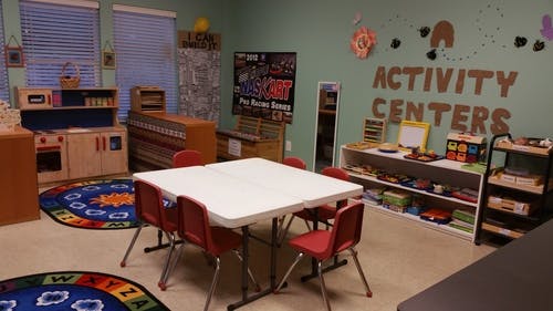 Classroom with play kitchen, tables, and activity centers