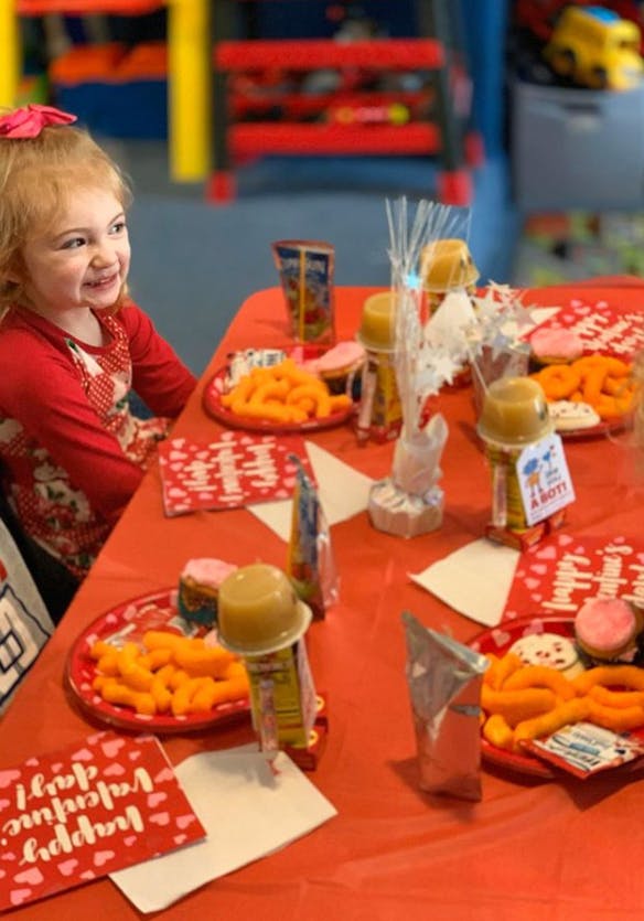 Child sitting at a table with snacks and juice pouches