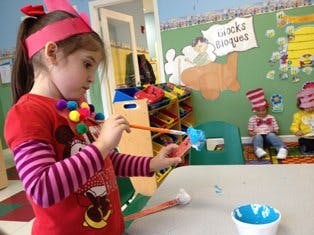 Child painting in a classroom