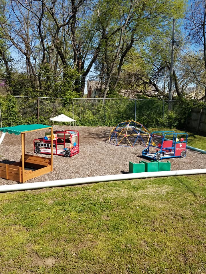 Playground with sandbox, fire truck play structure, and climbing dome