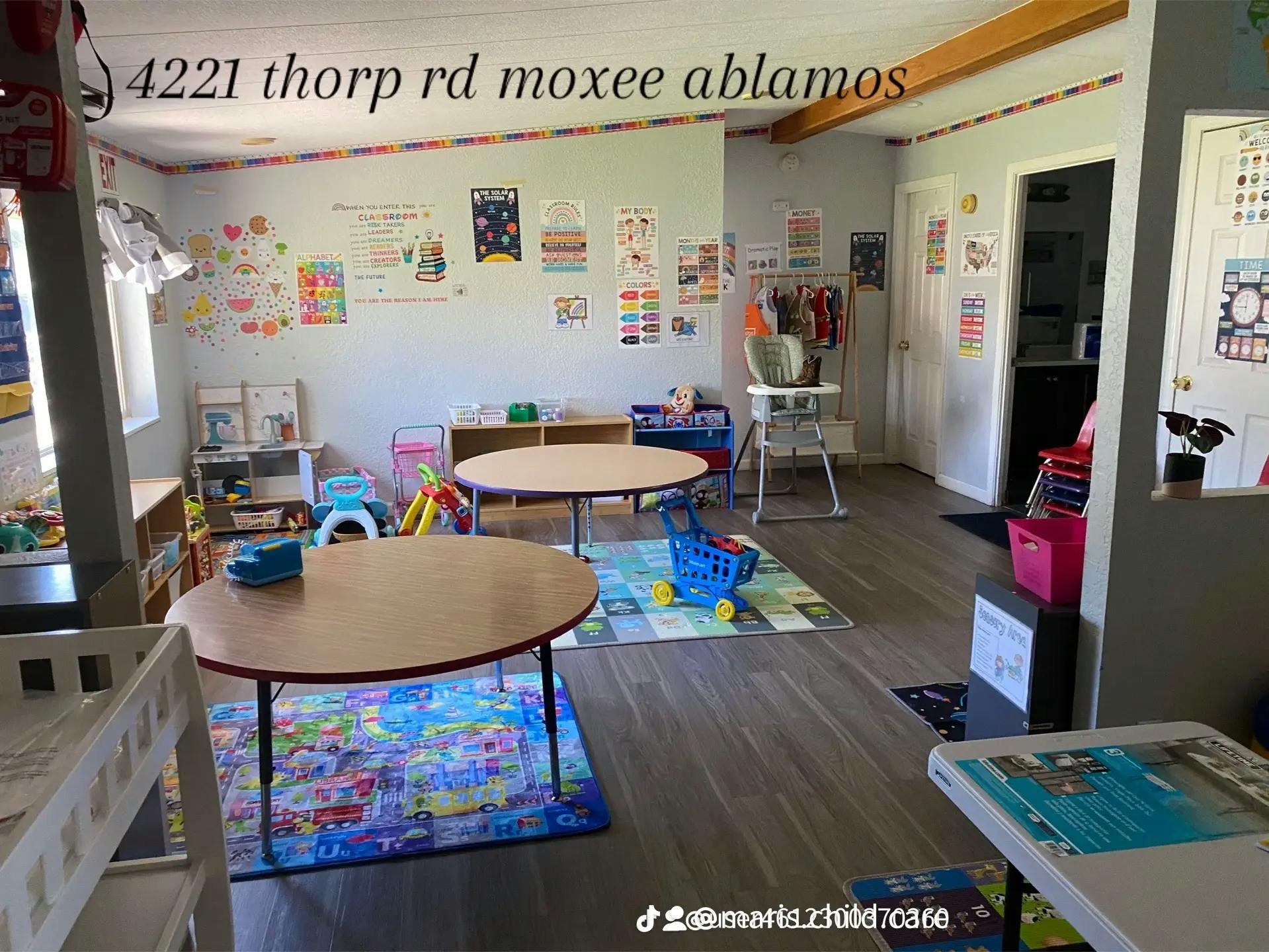 Childcare room with small tables, chairs, and colorful decorations