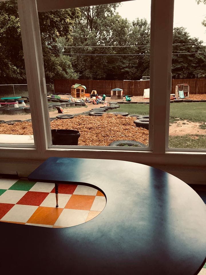 Playground with small structures and tires viewed through a window