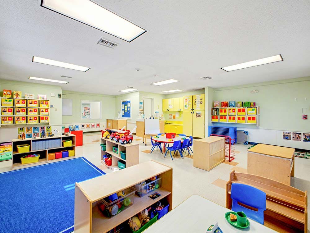 Classroom with child-sized furniture, shelves of toys and books