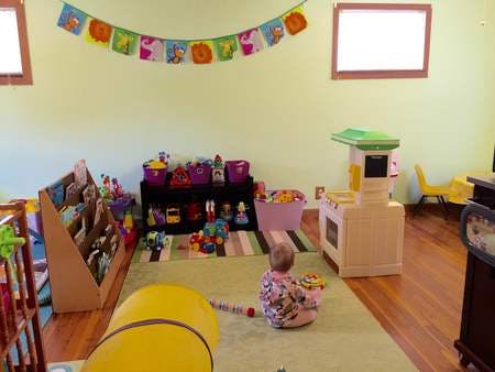 Child playing in a room with toys and a play kitchen