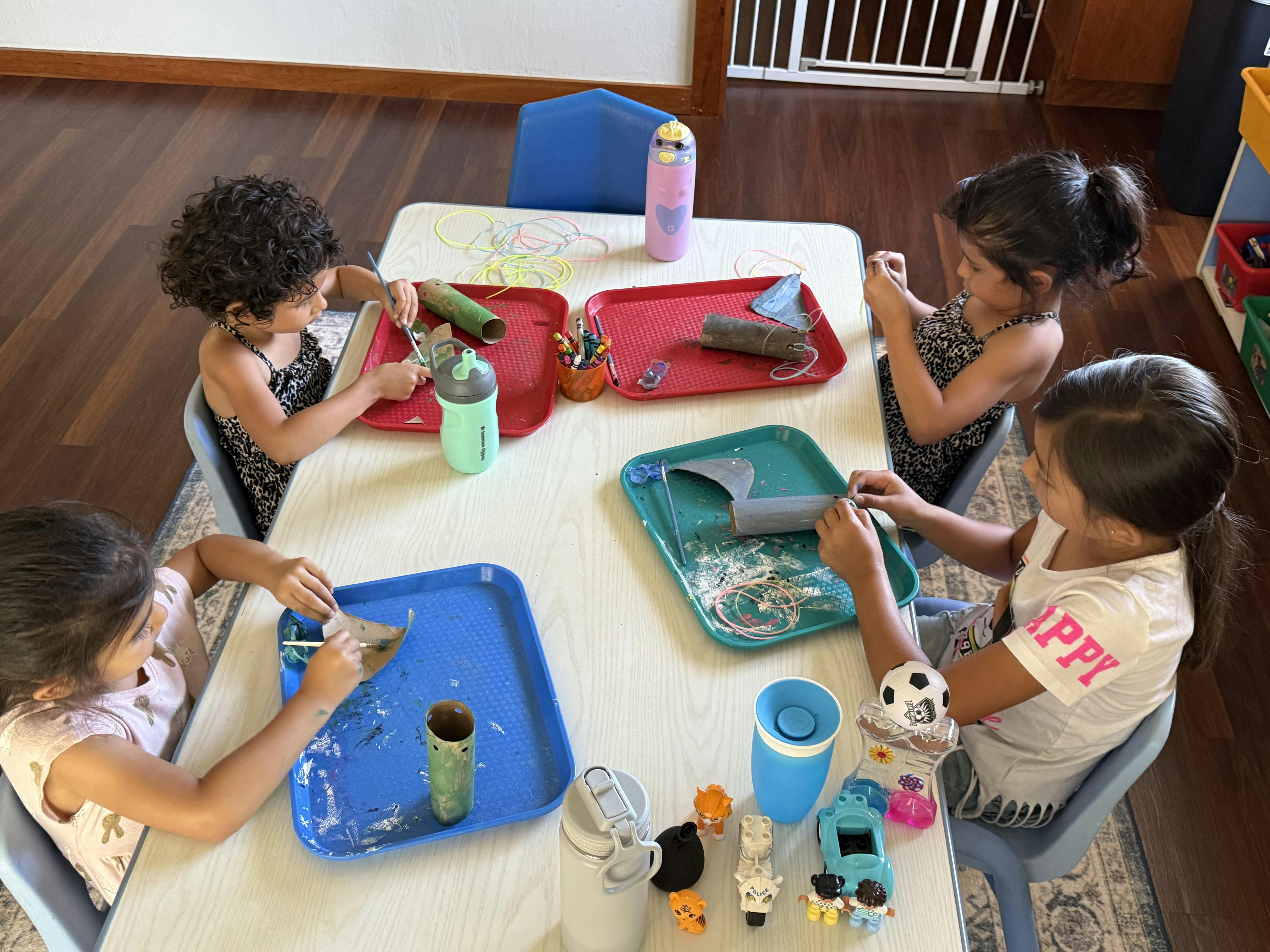 Four children doing crafts at a table