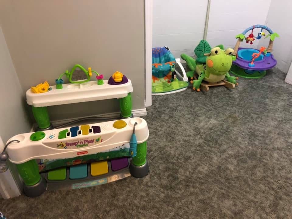 Children's play area with a toy piano, activity table, and frog toy