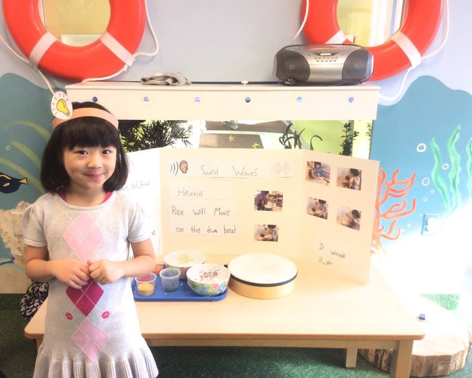 Child standing in front of a science fair project