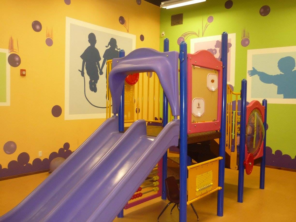 Indoor playground with a purple slide and colorful walls