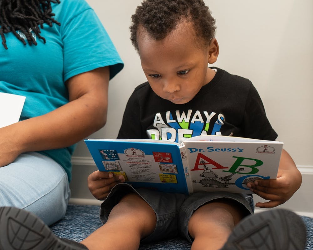Child sitting and reading a Dr. Seuss ABC book