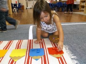 Child playing with colorful shapes on a striped mat