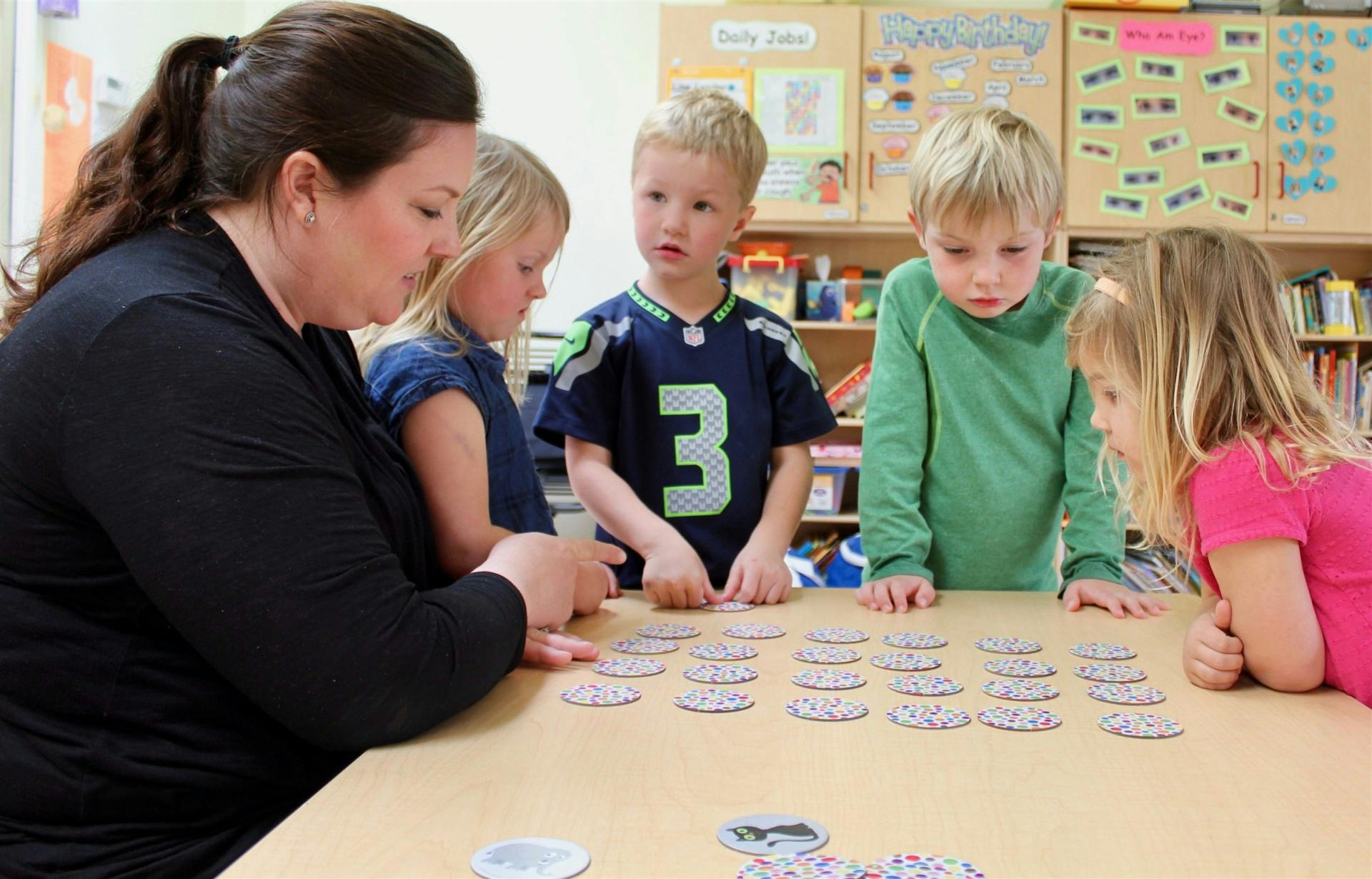 Adult and children playing a matching game at a table