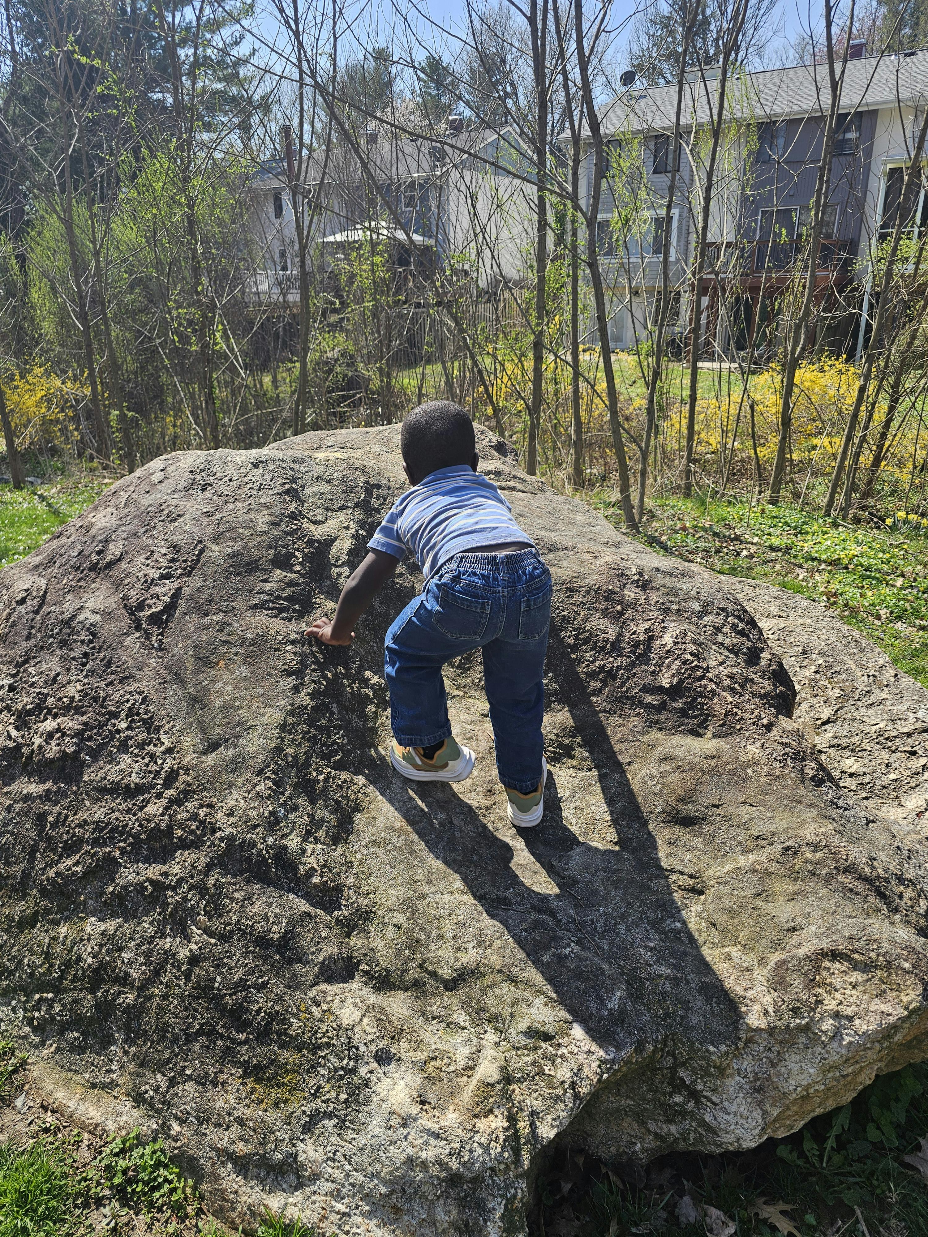 Child crawling on a large rock