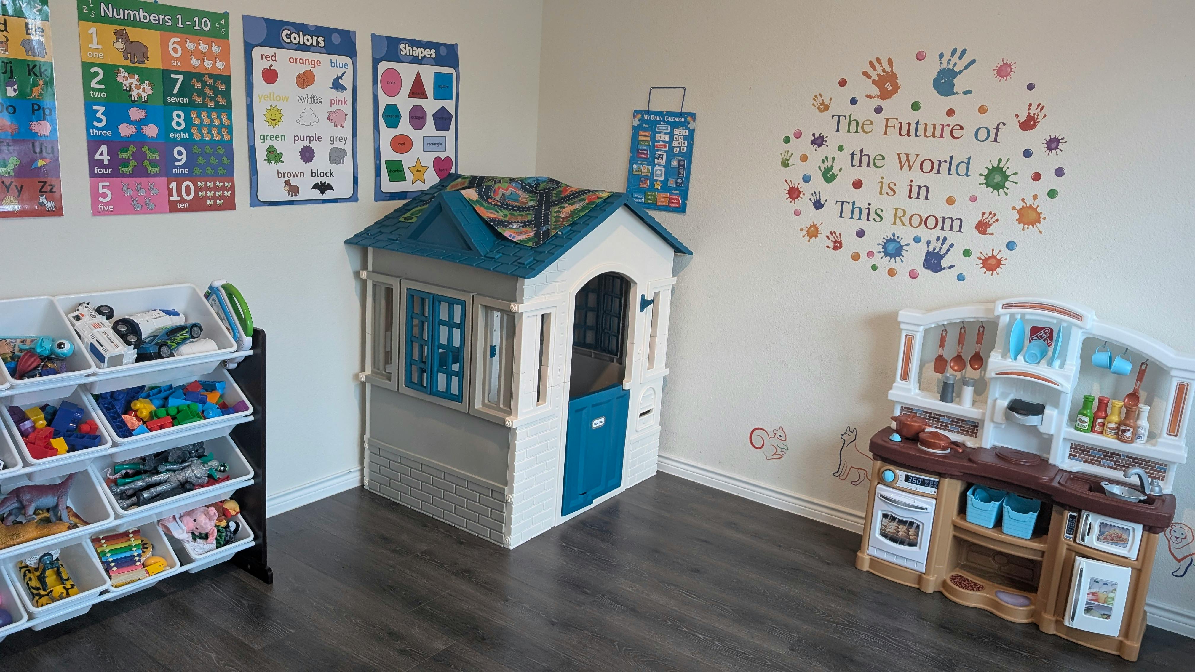 Playroom with a toy house, storage shelves, and a play kitchen