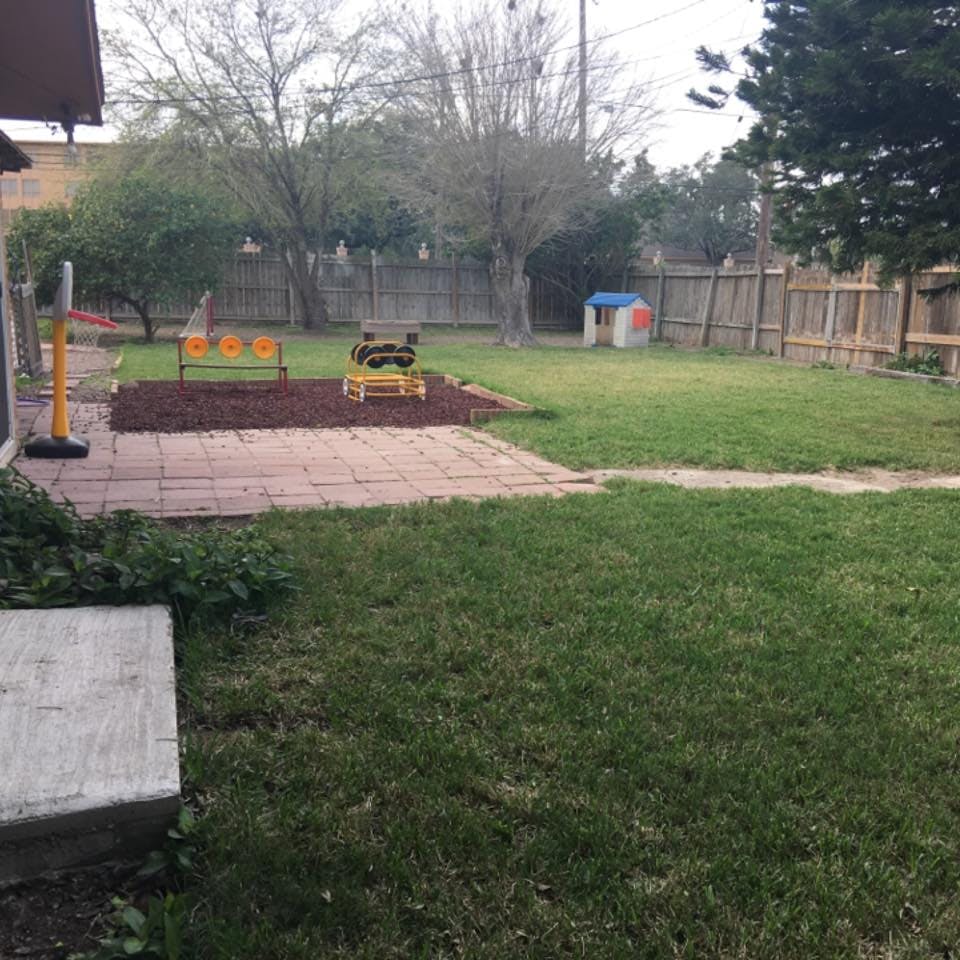Backyard with a small patio, play area, and shed