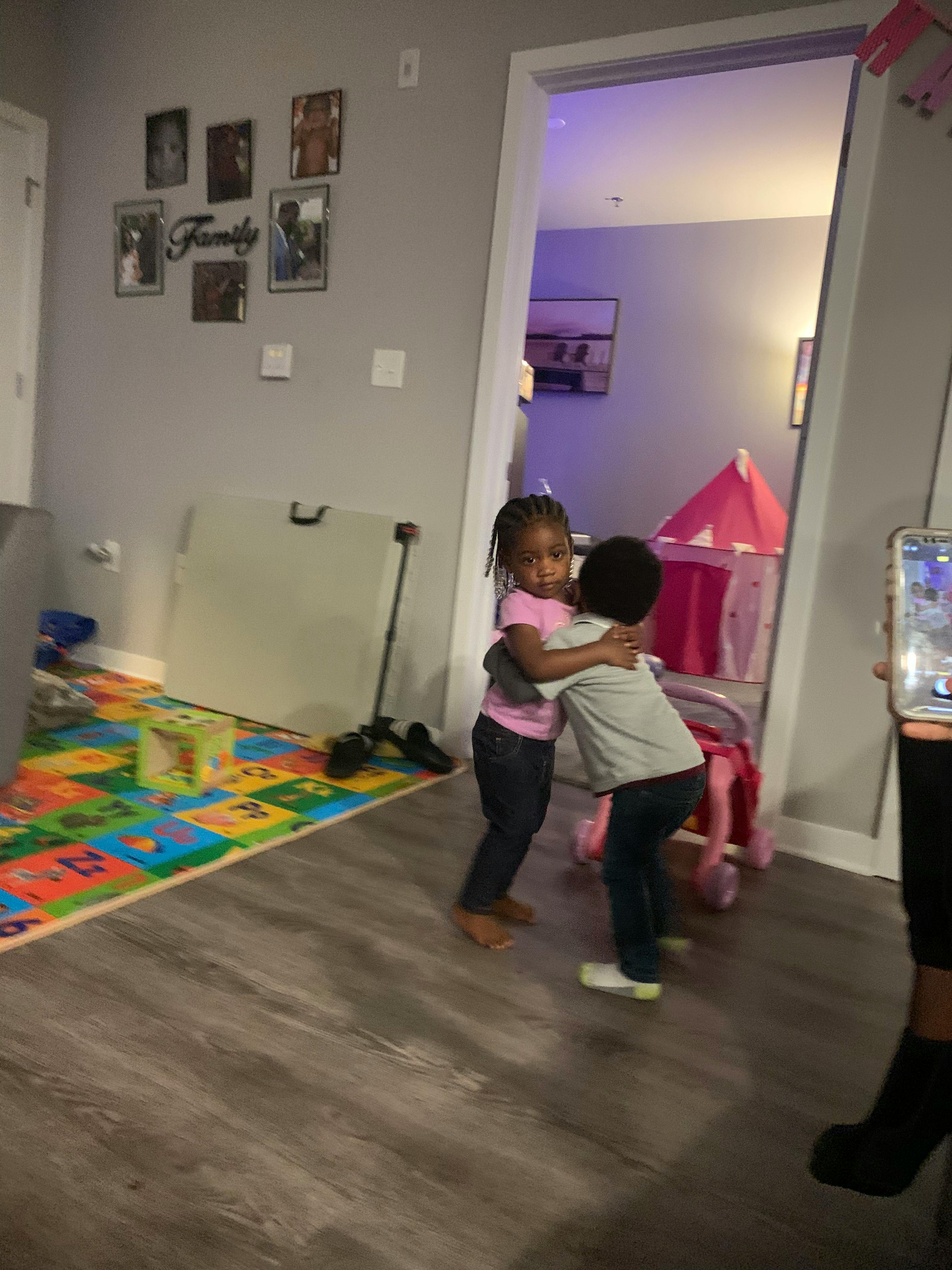 Two children hugging in a room