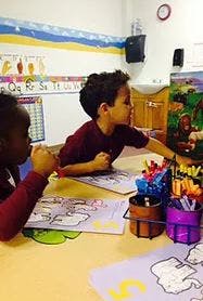 Two children drawing at a table