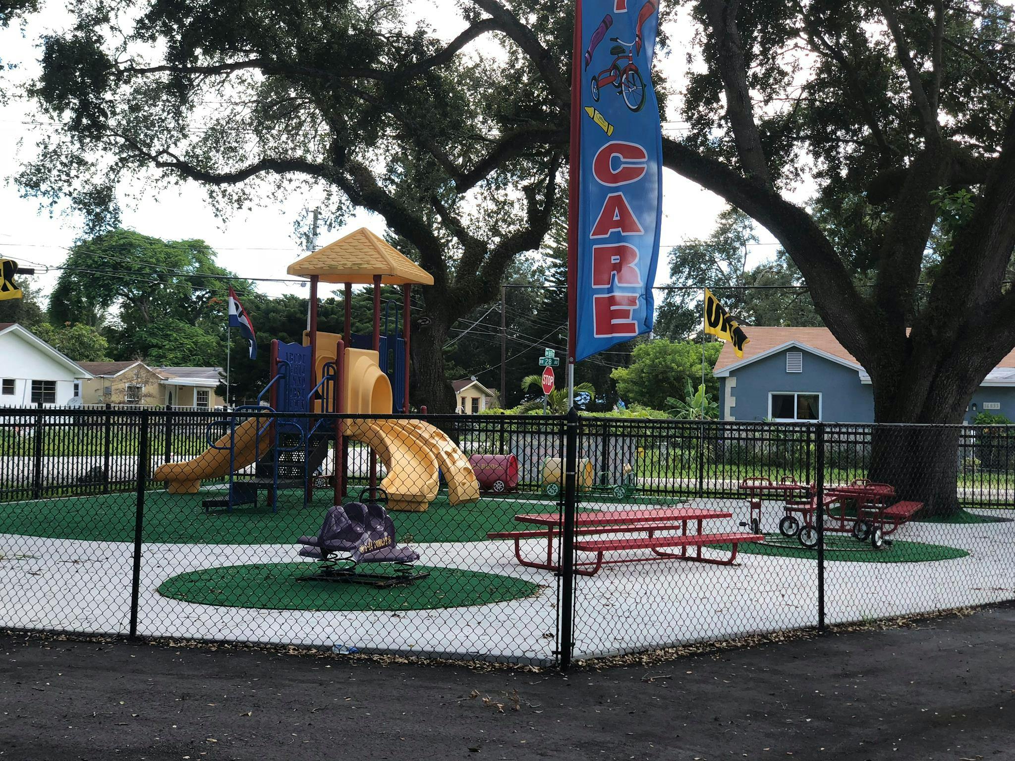 Playground with slides, picnic tables, and a banner that says "CARE"