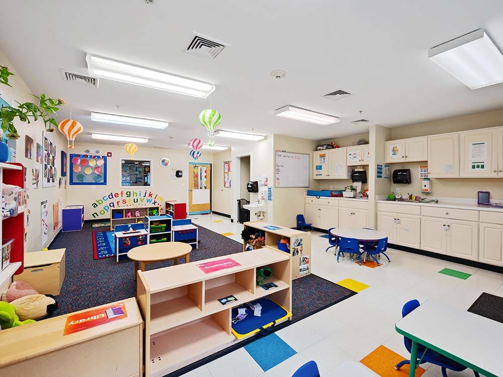Empty colorful preschool classroom with small tables and chairs