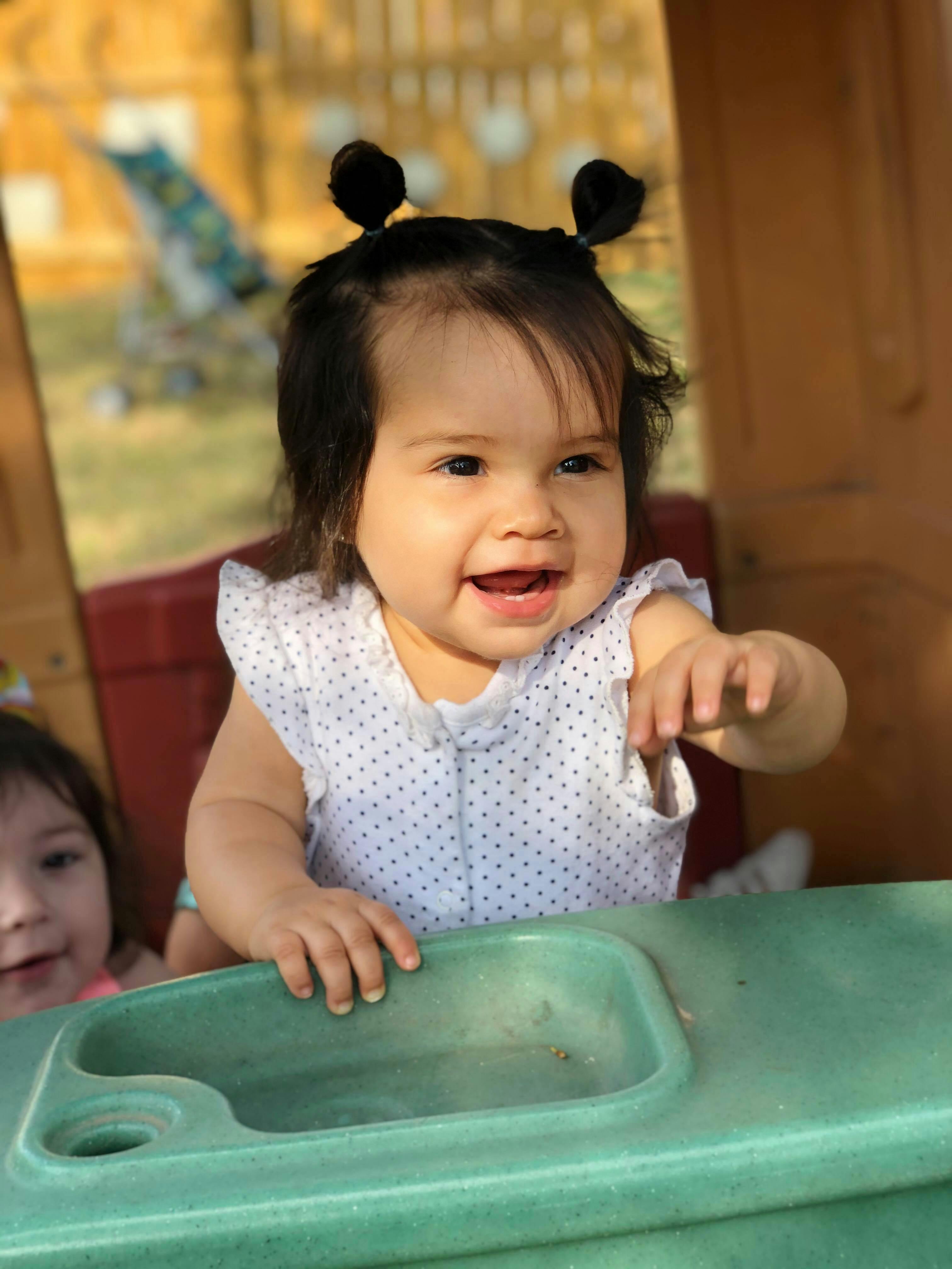 Child with hair in two buns smiling