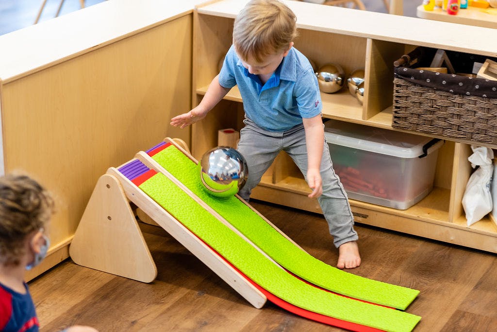 Child playing with a ball on a ramp