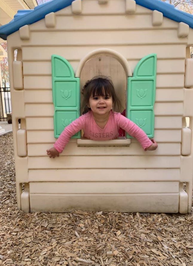 Child looking out of a playhouse window