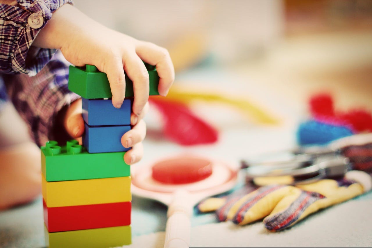 Child stacking colorful building blocks