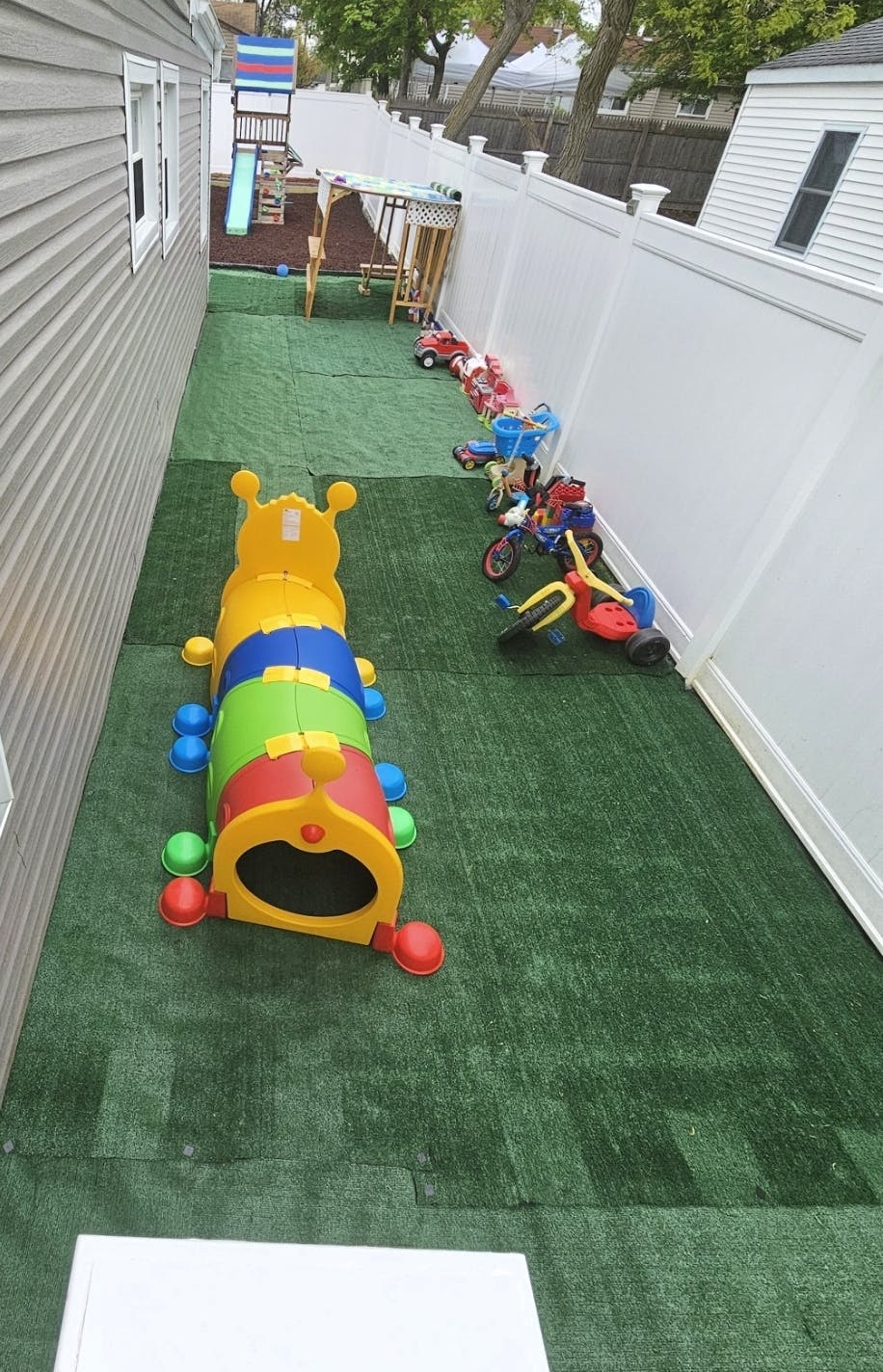 Playground with a caterpillar tunnel and various ride-on toys