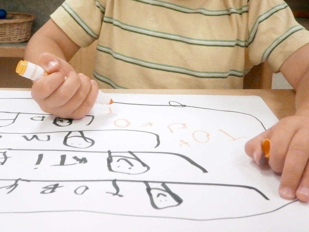 Child drawing on paper with a marker