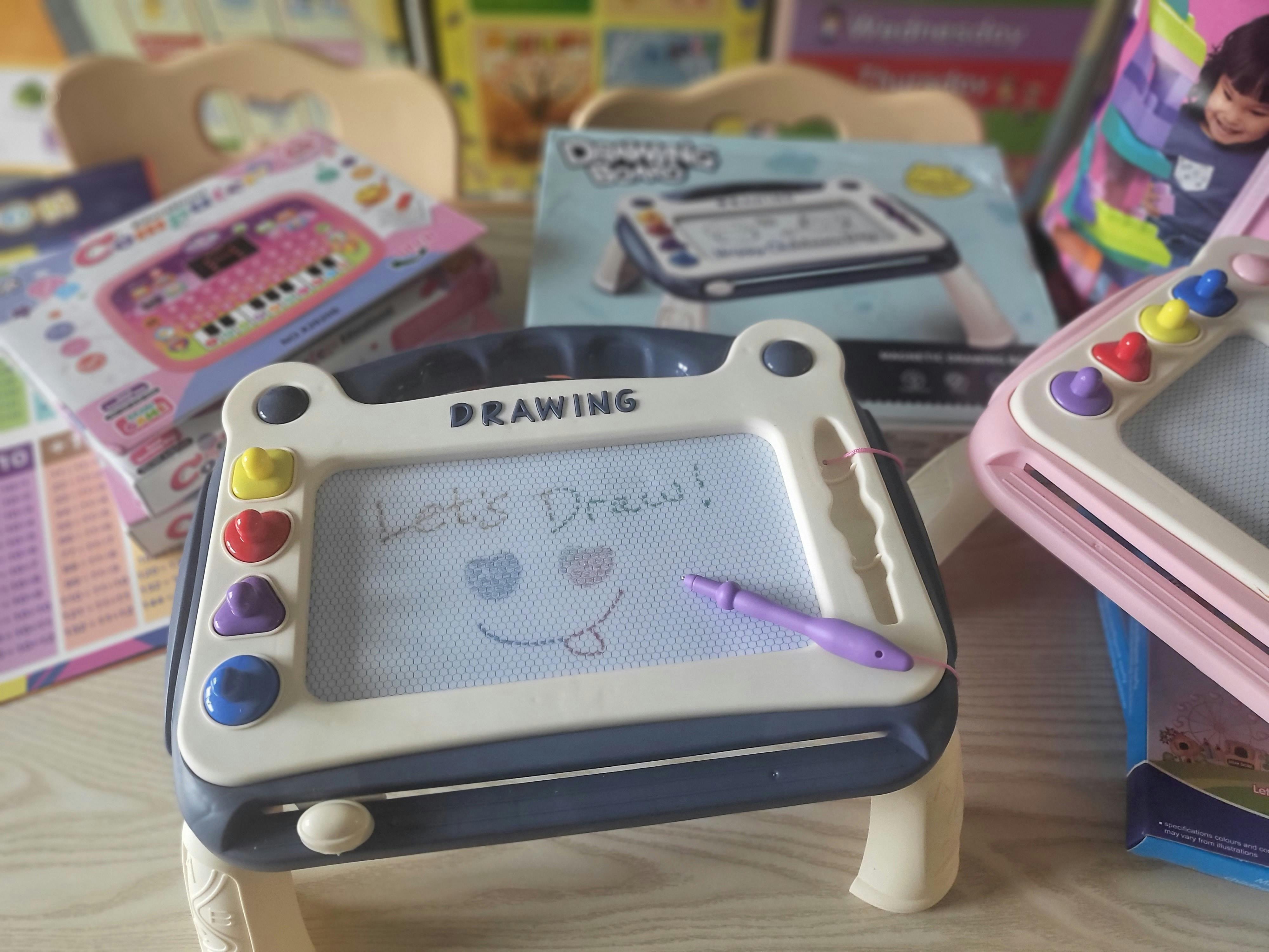 Magnetic drawing board with "Let's Draw!" and a smiley face written on it