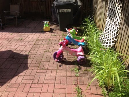Children's ride-on toys on a brick patio