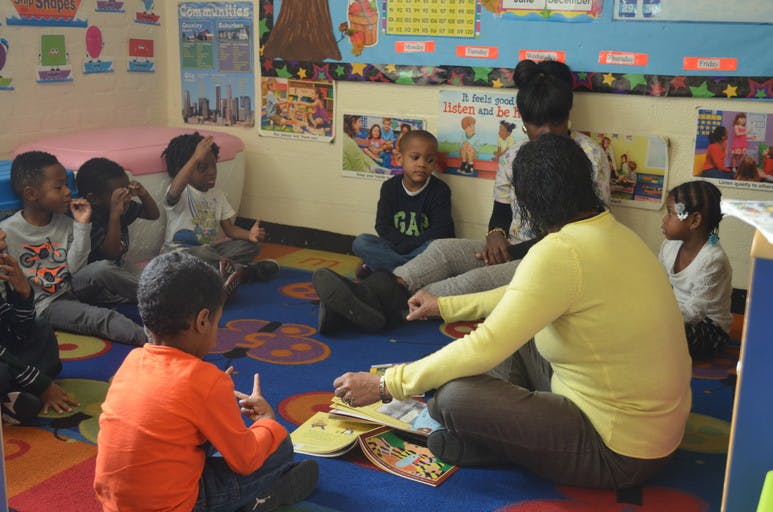 Adult reading to children in a classroom