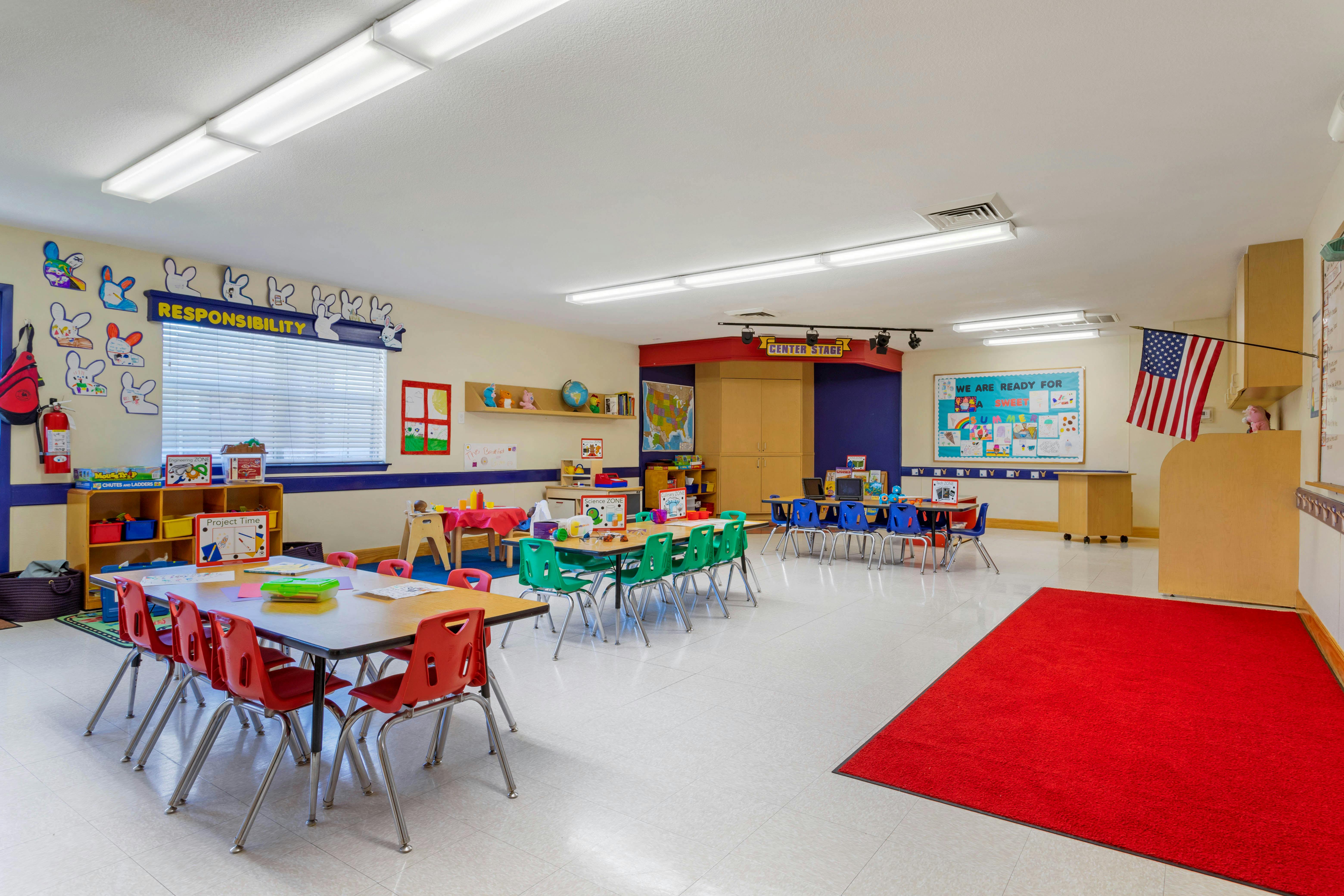 Classroom with tables, chairs, and colorful decorations on the walls