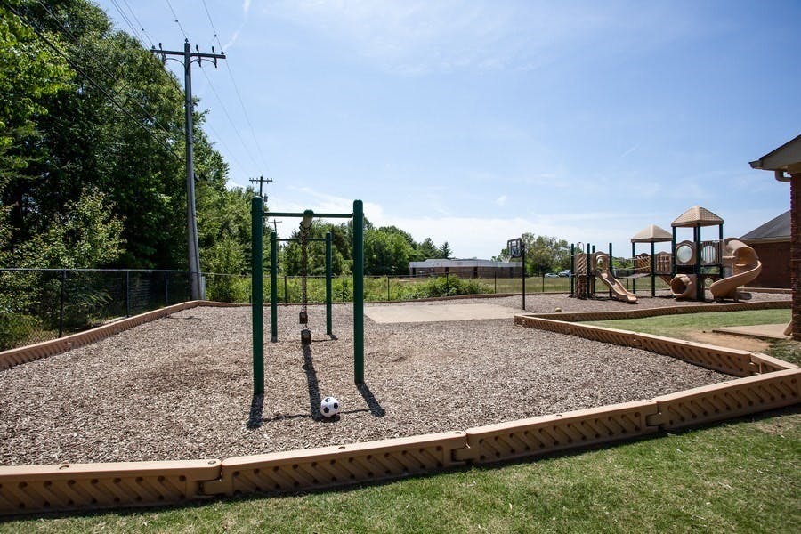 Playground with monkey bars and a soccer ball on wood chips