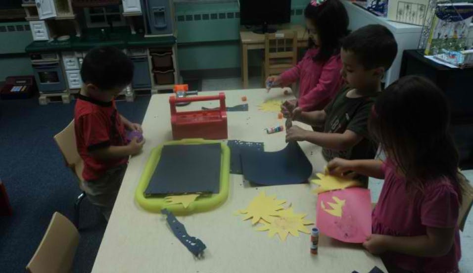 Children at a table doing crafts with paper crafts