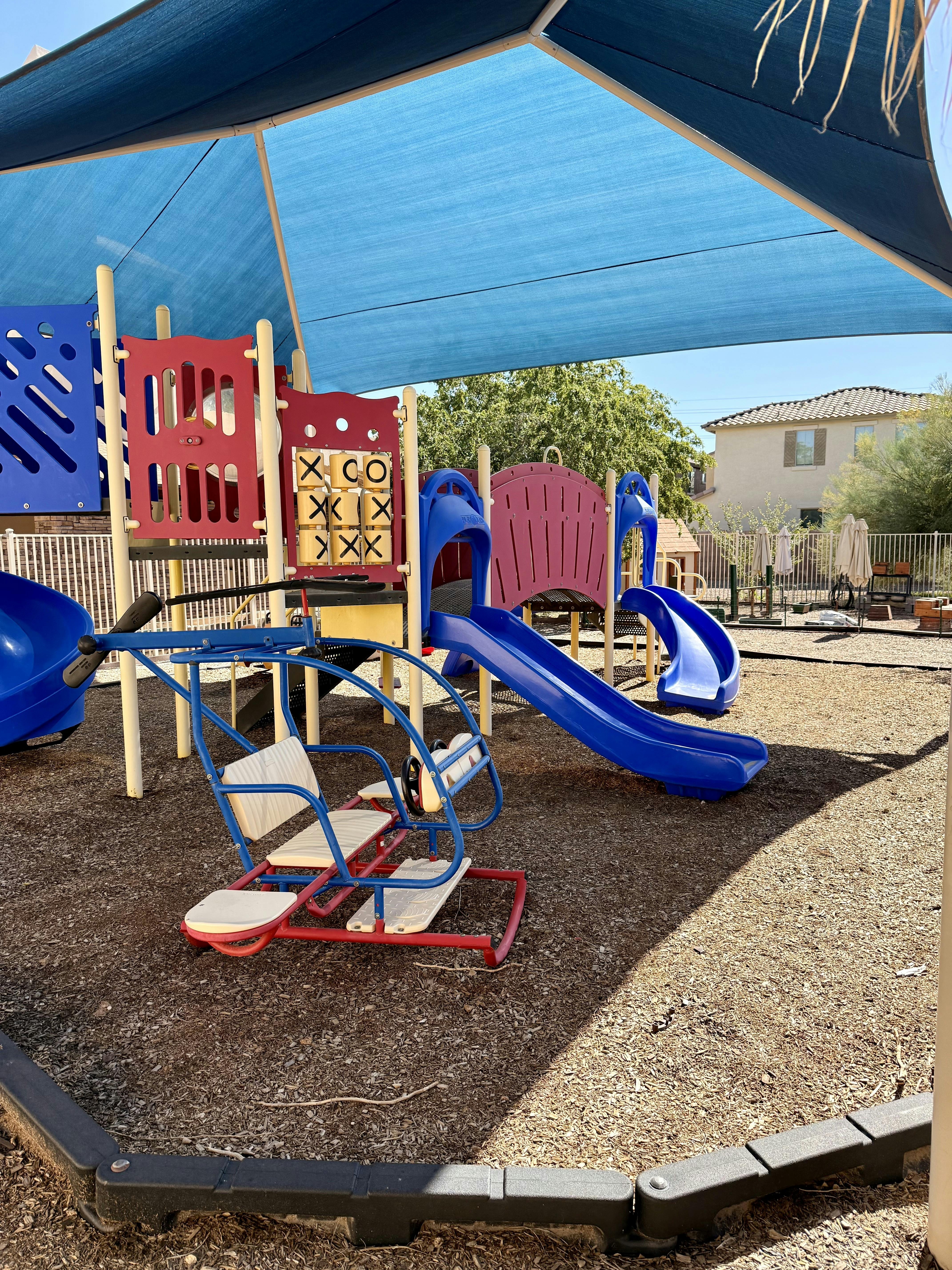 Playground with blue slides and a red and blue helicopter ride-on toy