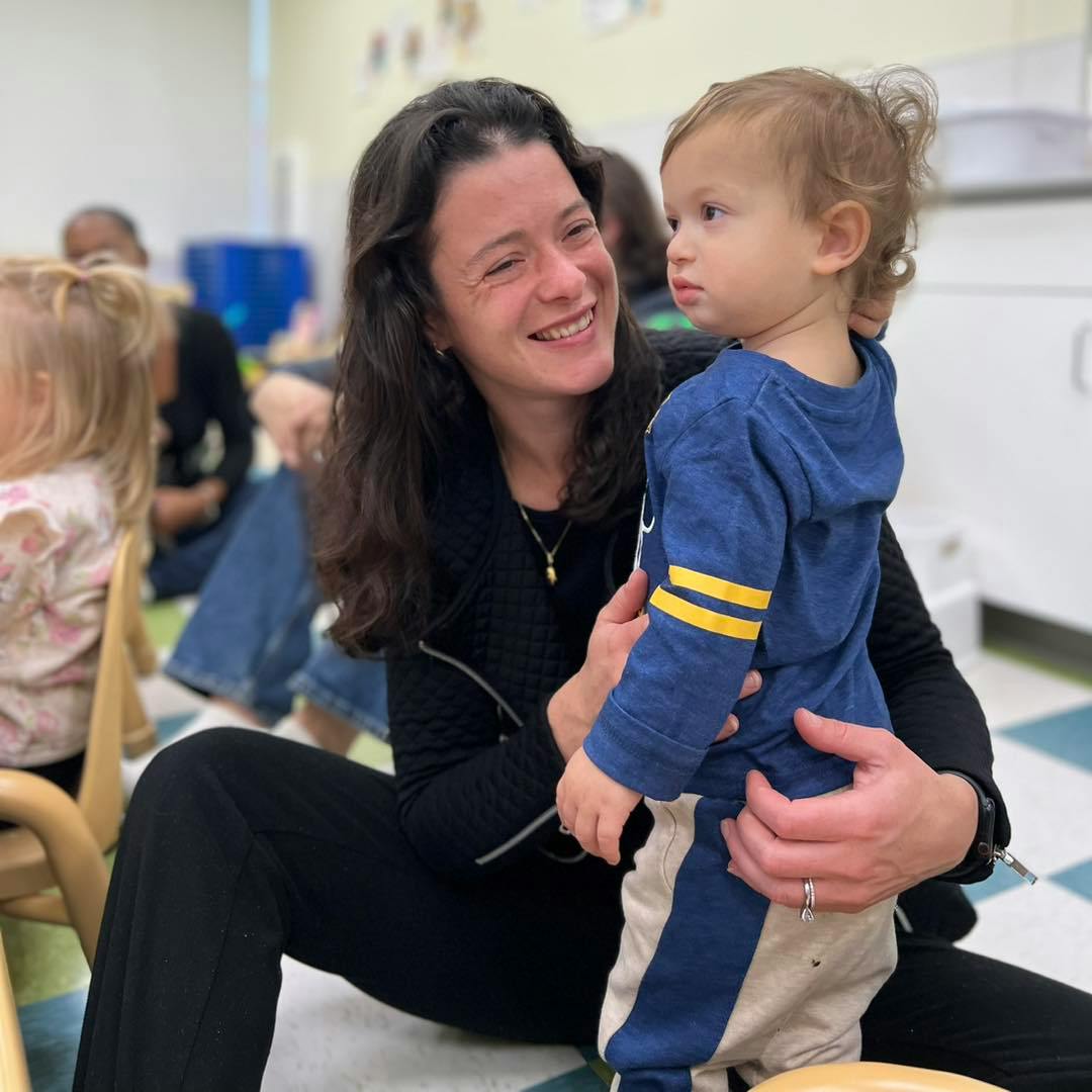 Person holding a child in a classroom