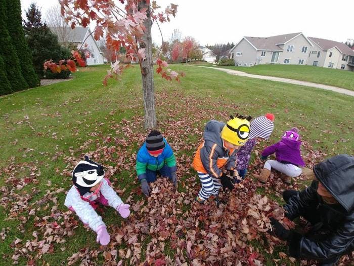 Children playing in a pile of autumn leaves